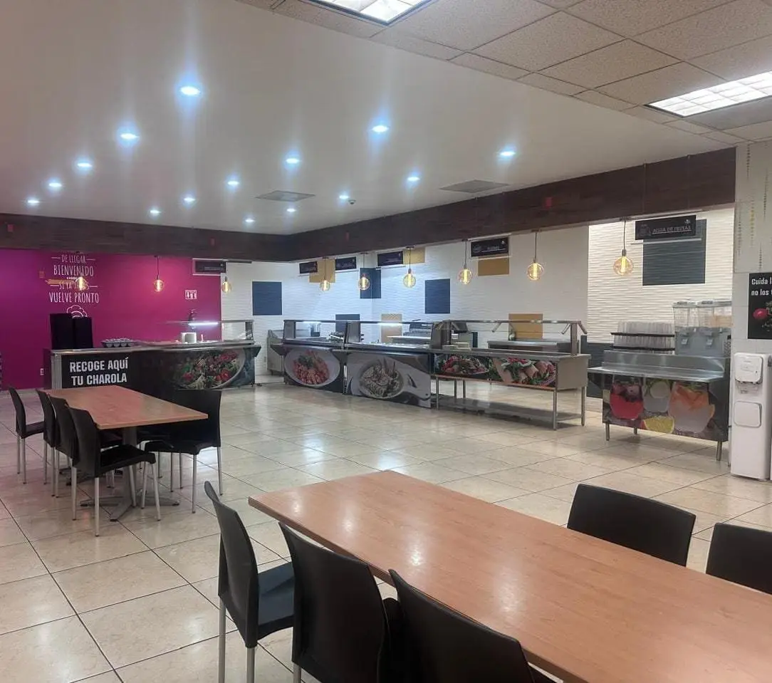 Área de comedor con mobiliario y barra de servicio de alimentos