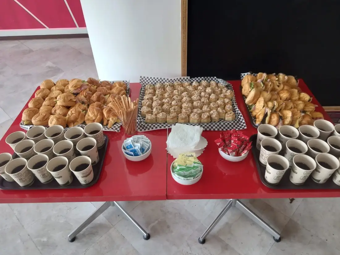 Mesa con panes, postres y bebidas para un coffee break